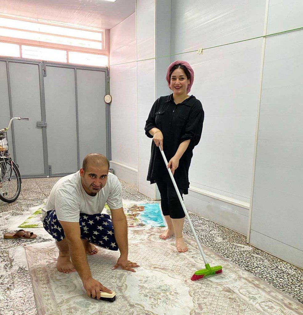 an iranian couple cleaning persian rug at home by water and soap