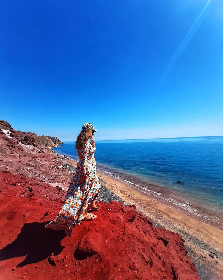 a local woman in the red soil of hormuz beach in iran