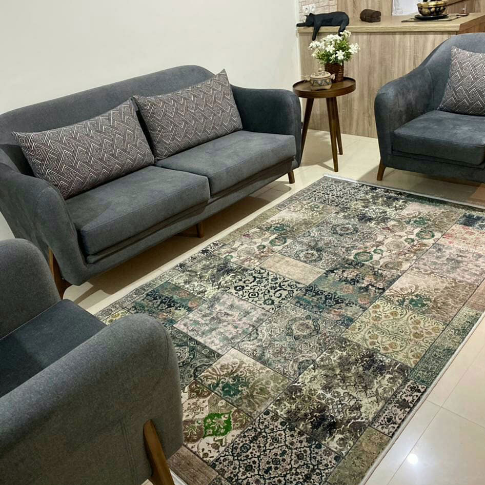 green persian rug in the middle of gray sofas