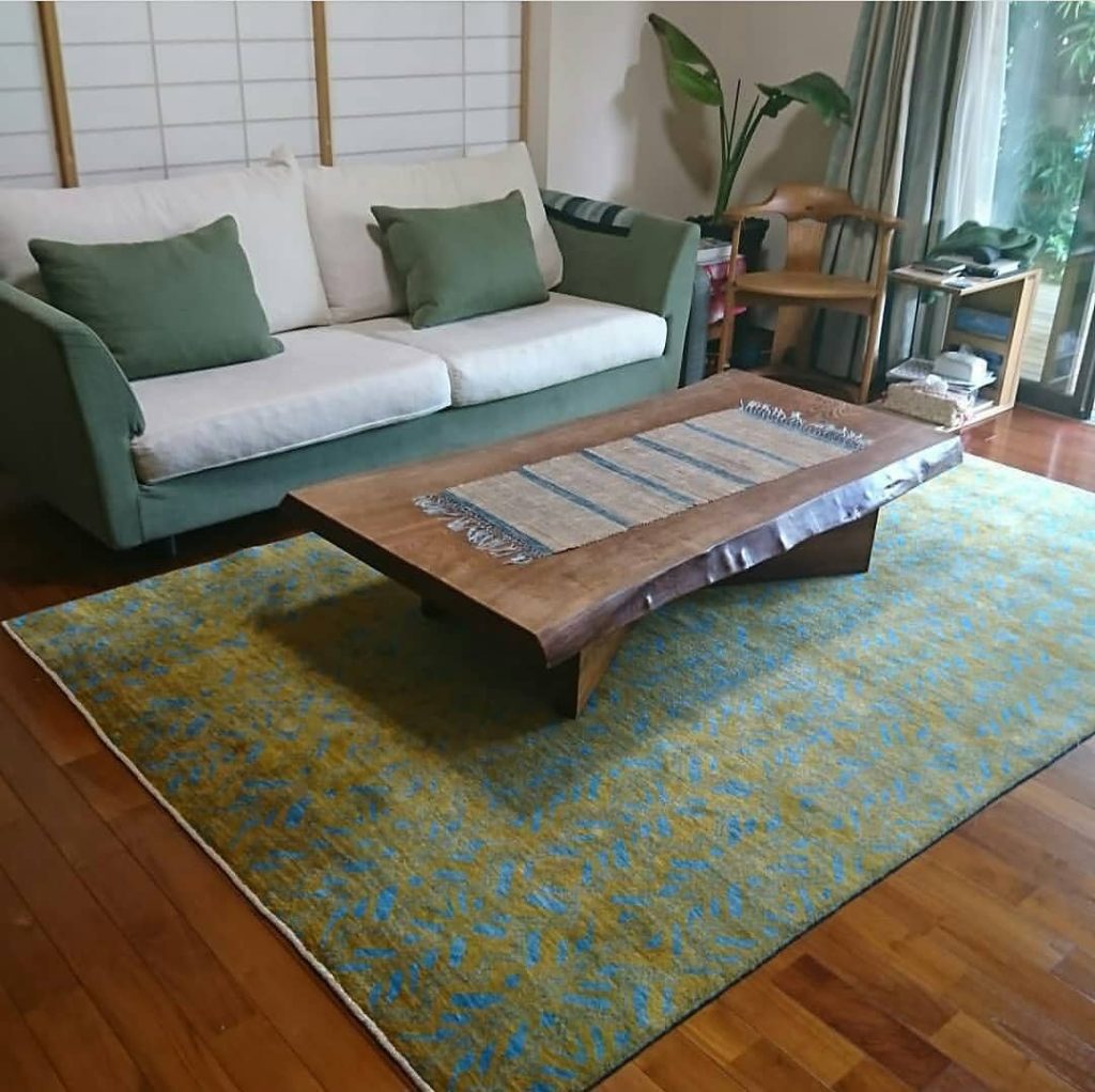 vintage green persian rug in a room net to green cushions and white sofa