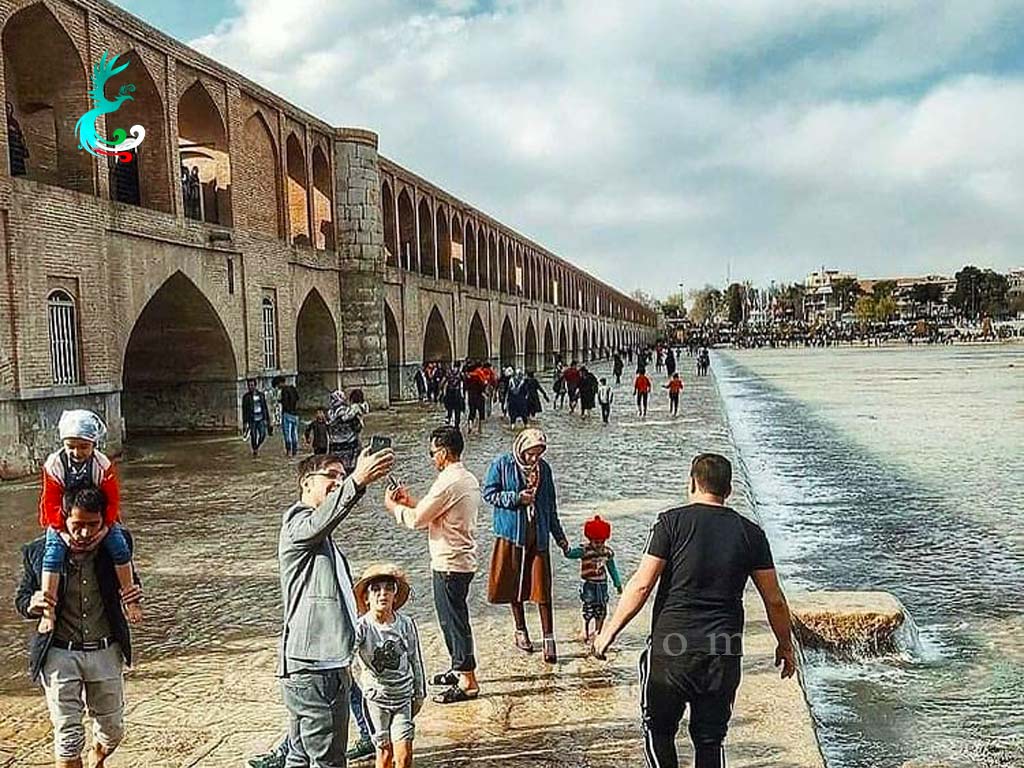 people in front of khaju bridge in isfahan